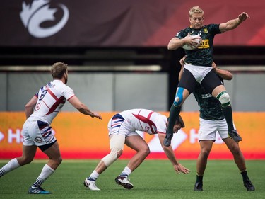 CORRECTS NAMES OF US PLAYERS South Africa's Kyle Brown, front right, grabs the ball away from United States' Brett Thompson, second left, and Nick Boyer, left, during World Rugby Sevens Series bronze medal game action, in Vancouver, B.C., on Sunday March 11, 2018.