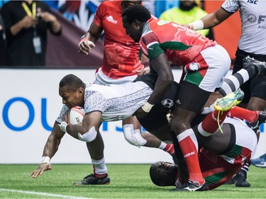 Fiji's Paula Dranisinukula, left, scores a try as Kenya's Collins Injera, centre, and Andrew Amonde, back right, defend during World Rugby Sevens Series final action, in Vancouver, B.C., on Sunday March 11, 2018.