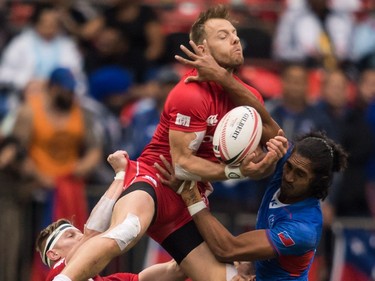 Canada's Harry Jones, top, is lifted by John Moonlight, left, as he vies for the ball against Samoa's Silao Nonu, right, during World Rugby Sevens Series action, in Vancouver, B.C., on Sunday March 11, 2018.