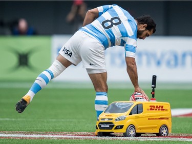 Argentina's Gaston Revol picks up the game ball from a remote controlled DHL van before playing Australia during World Rugby Sevens Series action, in Vancouver, B.C., on Sunday March 11, 2018.