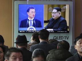FILE - In this March 7, 2018, file photo, people watch a TV screen showing images of North Korean leader Kim Jong Un and South Korean President Moon Jae-in, left, at the Seoul Railway Station in Seoul, South Korea. The rival Koreas have agreed Saturday, March 24, to hold high-level talks next week to prepare for an April summit between North Korean leader Kim Jong Un and South Korean President Moon Jae-in.