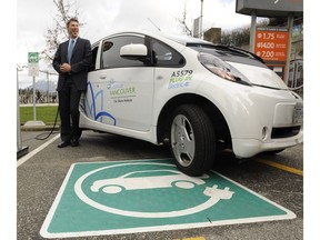 City council will vote this week on a bylaw amendment that would require all parking spots in new condos be equipped for electric vehicle charging. Mayor Gregor Robertson is pictured in this file photo posing with one of the city's electric vehicles and charging stations.