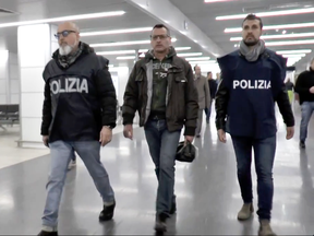 Tito Figliomeni accompanied by police officers after arriving in Rome.