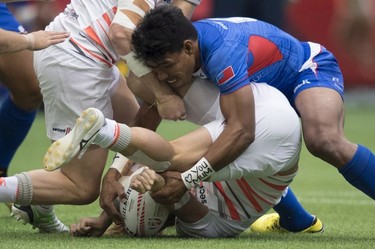 Murphy Paulo of Samoa (right) puts Dan Biddy of England to the pitch during the World Rugby Seven Series at B.C. Place in Vancouver, Saturday, March 10, 2018.