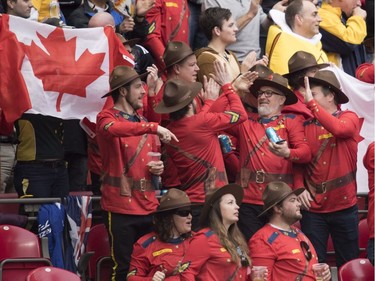 Rugby fans dressed as RCMP members give high fives after team Canada scored a try during the World Rugby Seven Series match against Australia at B.C. Place on Saturday, March, 10, 2018.
