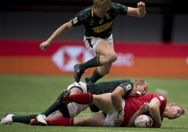 Alec Coombes of Scotland is tackled by Philip Snyman and Dylan Sage of South Africa during the World Rugby Sevens Series at B.C. Place in Vancouver, Saturday, March, 10, 2018.
