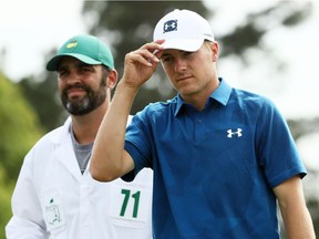 Jordan Spieth tips his cap on the 18th green alongside caddie Michael Greller during the second round of the 2018 Masters Tournament at Augusta National Golf Club on April 6, 2018 in Augusta, Georgia.