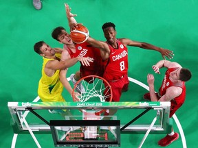 Erik Nissen (L) and Jean-Victor Mukama (R) of Canada rebound next to Daniel Kickert of Australia during the Men's Gold Medal Basketball Game between Australia and Canada on day 11 of the Gold Coast 2018 Commonwealth Games at Gold Coast Convention and Exhibition Centre on April 15, 2018 on the Gold Coast, Australia.