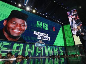 A video board displays an image of Rashaad Penny of San Diego State after he was picked #27 overall by the Seattle Seahawks during the first round of the 2018 NFL Draft at AT&T Stadium on April 26, 2018 in Arlington, Texas.