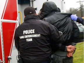 Abbotsford Police anti-gang officers lead away one of two men arrested on April 5.
