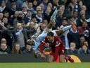 Manchester City's Raheem Sterling goes flying as he is challenged by Liverpool's Virgil van Dijk during the  Champions League, quarter-final second leg soccer match on April 10 at the Etihad Stadium in Manchester, England.