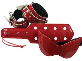 This product image released by Babeland shows a blindfold, a paddle and wrist and ankle restraints in red patent leather. AP file photo.