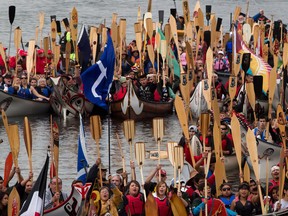 Paddlers raise their paddles as they gather on Vancouver's False Creek during an all nations canoe gathering held as part of Reconciliation Week in Vancouver, B.C., on Tuesday September 17, 2013.