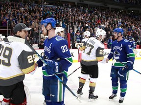 Henrik and Daniel Sedin shake hands with Shea Theodore and Marc-Andre Fleury of the Vegas Golden Knights after their game at Rogers Arena.