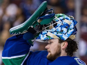 Vancouver Canucks' goalie Thatcher Demko puts on his helmet during first period NHL hockey action against the Columbus Blue Jackets, in Vancouver on Saturday, March 31, 2018.