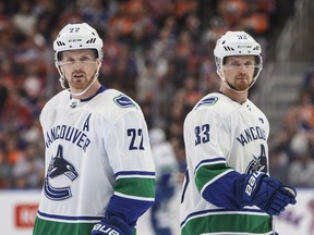 Vancouver Canucks' Daniel Sedin and Henrik Sedin skate past each other against the Edmonton Oilers during first period NHL action in Edmonton on Saturday April 7, 2018.