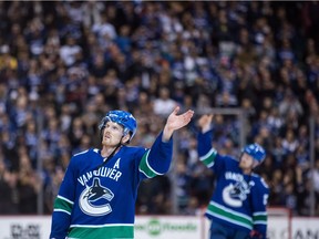 Daniel Sedin and Henrik Sedin wave to the crowd after defeating the Arizona Coyotes 4-3.