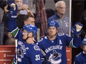 Henrik and Daniel Sedin wave to the crowd during a standing ovation in the third period.