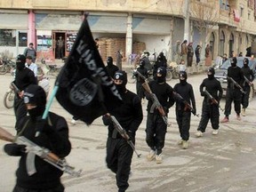 Fighters from the al-Qaida linked Islamic State of Iraq and the Levant (ISIL), now called the Islamic State group, marching in Raqqa, Syria in April, 2018.