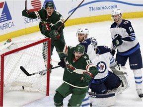 Minnesota Wild left wing Marcus Foligno (17) and Wild center Joel Eriksson Ek (14) celebrate after Foligno scored a goal on Winnipeg Jets goalie Connor Hellebuyck (37) and Jets' Ben Chiarot (7) and Jacob Trouba (8) in the second period of Game 3 of an NHL first-round hockey playoff series Sunday, April 15, 2018, in St. Paul, Minn.