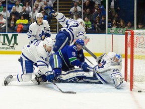 Zack MacEwen of the Utica Comets battles in front of outstretched Toronto Marlies' netminder Garret Sparks during Friday's AHL playoff action in Utica, N.Y. Toronto defenceman Vincent LoVerde keeps his eye on the loose puck. The Comets tied the best-of-five series 2-2 with a 5-2 victory.