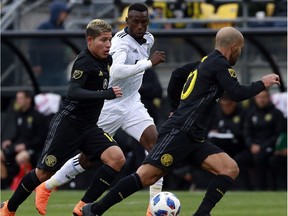 Columbus Crew midfielder Cristian Martinez, left, moves the ball alongside Vancouver Whitecaps' forward Bernie Ibini-Isei during MLS action in Columbus, Ohio on March 31.