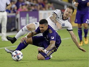 Former Vancouver Whitecaps Jordan Harvey, shown getting tangled up with Orlando City's Dom Dwyer last August, will be honoured by the Caps before his Los Angeles FC play at B.C. Place Stadium tonight.