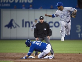 Toronto Blue Jays catcher Russell Martin (55) slides safely into second base as Kansas City Royals shortstop Alcides Escobar (2) leaps during third inning AL baseball action in Toronto on Wednesday, April 18, 2018.