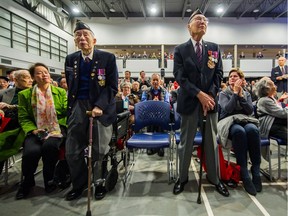 War veterans Monty Lee, left, and Ronald Lee stand and are acknowledged as Mayor Gregor Robertson and Vancouver city council make an apology to the Chinese community for past injustices at the Chinese Cultural Centre in Vancouver on April 22.