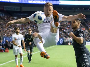 Former Vancouver Whitecap Jordan Harvey, now with L.A. FC, was honoured before Friday's MLS game in Vancouver. Here he jumps to try and kick the ball away from Whitecaps' Cristian Techera, right, during second-half action.