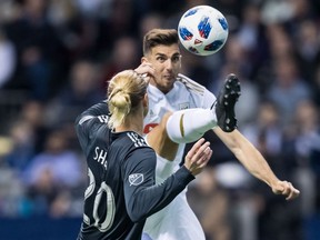 Los Angeles FC's Dejan Jakovic, back, leaps to kick the ball away from Vancouver Whitecaps' Brek Shea during second half MLS soccer action in Vancouver, B.C., on Friday April 13, 2018.