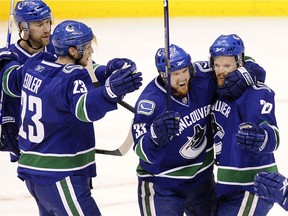 The Sedins and Alex Edler and Mattias Ohlund celebrate a playoff goal against Chicago in 2009.