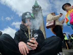 A man smokes marijuana from a bong during the annual 4/20 pot celebration on Parliament Hill in Ottawa on April 20.