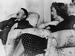 Adolf Hitler asleep in an armchair watched by his mistress Eva Braun.