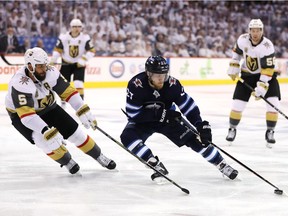 Nikolaj Ehlers of the Winnipeg Jets is defended by Deryk Engelland of the Vegas Golden Knights during the second period of Winnipeg's 4-2 victory.