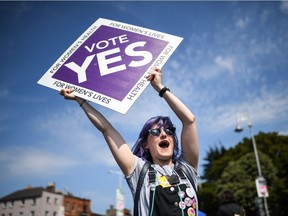 Members of the public hold yes placards on Fairview Road as Ireland heads to polling stations on May 25, 2018, to decide whether to abolish the 8th amendment making abortions illegal in the country, except for circumstances where the mother's life is at risk.