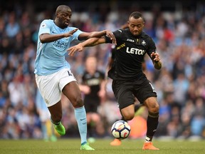 anchester City's Ivorian midfielder Yaya Toure (L) vies with Swansea City's Ghanaian striker Jordan Ayew during the English Premier League football match between Manchester City and Swansea at the Etihad Stadium in Manchester, north west England, on April 22, 2018.