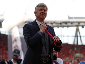 Arsenal manager Arsene Wenger starts to take off his tie at the end of an English Premier League match against Burnley at Emirates Stadium in London on May 6, 2018. Wenger is leaving the north London club after 22 years in charge.