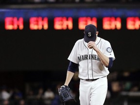 Seattle Mariners starting pitcher James Paxton gets ready for the next batter after striking out an Oakland Athletics player as a line of "eh's," a nod to Paxton's Canadian heritage and his strikeout count, appears on a scoreboard during the seventh inning of a baseball game Wednesday, May 2, 2018, in Seattle.