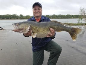 This Friday, May 18, 2018, photo provided by the North Dakota Game and Fish Department shows Neal Leier, of Bismarck, N.D. displays the 15-pound, 13-ounce walleye he caught on the Missouri River in Bismarck. The 32½-inch fish broke a state record that had stood of nearly six decades.