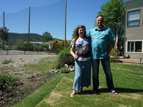 Colleen Gilmour and Thomas Scheffer stand outside their condo on Ellison Lake, where flooding last year caused signifiant damage to homes and covered the neighbouring golf course in sediment.