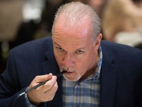 NDP Leader John Horgan uses chopsticks while eating lunch with local candidates and supporters during an election campaign stop at a Chinese restaurant in Vancouver.