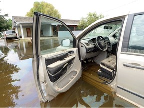 A minivan is submerged in floodwaters in Grand Forks, B.C., on Thursday, May 17, 2018.