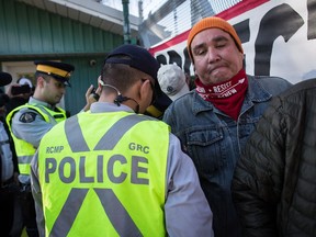 RCMP officers arrest protesters outside Kinder Morgan in Burnaby, B.C., on Saturday March 17, 2018. Approximately 30 people who blockaded an entrance - defying a court order - were arrested while protesting the Kinder Morgan Trans Mountain pipeline expansion. The pipeline is set to increase the capacity of oil products flowing from Alberta to the B.C. coast to 890,000 barrels from 300,000 barrels.