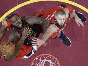 Cleveland Cavaliers' LeBron James (23) goes up for a shot between Toronto Raptors' OG Anunoby, left, and Jonas Valanciunas during the first half of Game 3 of an NBA basketball second-round playoff series Saturday, May 5, 2018, in Cleveland. (AP Photo/Tony Dejak) ORG XMIT: OHRS124