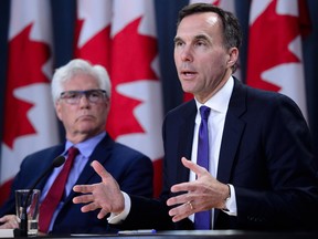 Finance Minister Bill Morneau, right, and Natural Resources Minister James Carr speak at the news conference in Ottawa Tuesday announcing the Trans Mountain deal.