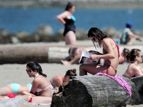 Beach goers enjoy the hot weather at Kits Beach, in Vancouver, BC.