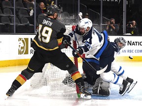Connor Hellebuyck tends the net as teammate Josh Morrissey of the Winnipeg Jets checks Reilly Smith of the Vegas Golden Knights at T-Mobile Arena on May 16, 2018 in Las Vegas. (Ethan Miller/Getty Images)