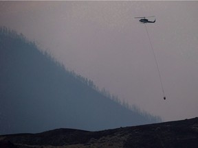 Stock image: A helicopter lands while battling a wildfire in B.C. in 2017.