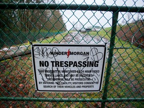 A "No Trespassing" sign is displayed on a fence outside of the Kinder Morgan Inc. facility in Burnaby, British Columbia.